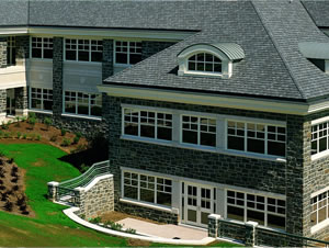 Large home with dark roofing and dormer windows