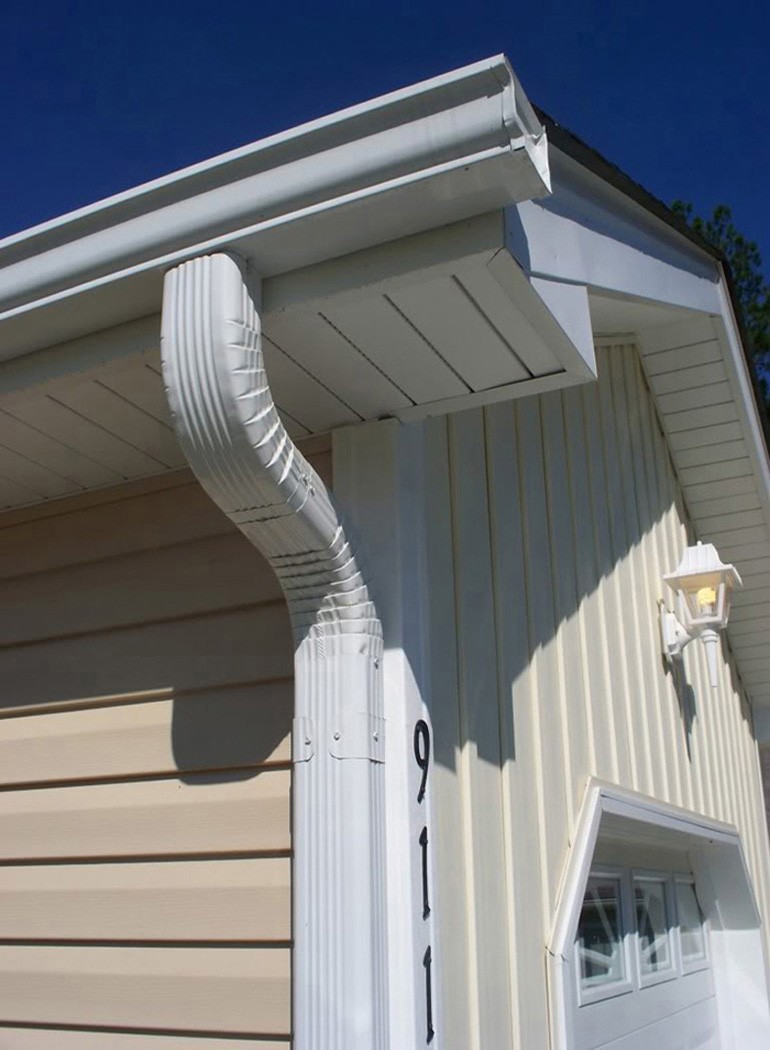 White gutter and downspout detail at a house corner
