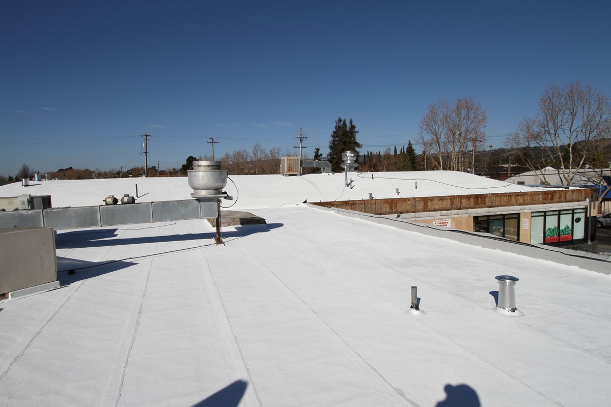 White flat roofing surface with rooftop vents