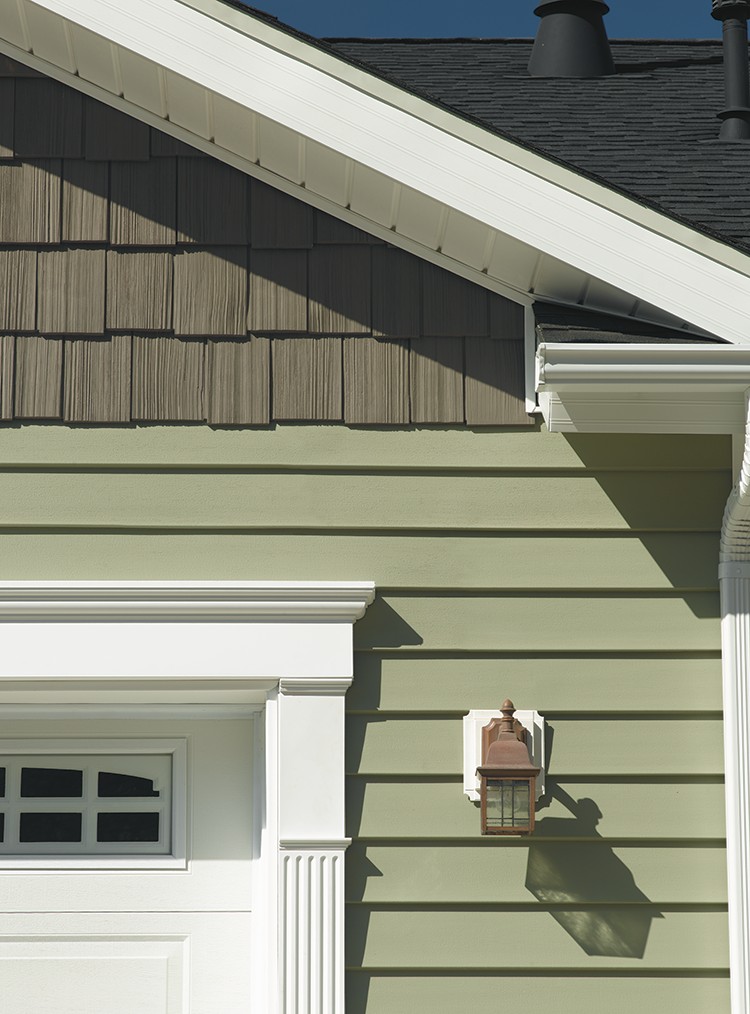 Siding, roof edge and white trim above a garage